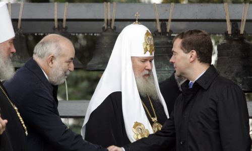 12 września 2008 r. Ówczesny prezydent Rosji Dmitrij Miedwiediew wita się z rosyjskim potentatem naftowym Wiktorem Wekselbergiem (z lewej) podczas ceremonii poświęcenia 18 dzwonów w klasztorze Daniłowskiego w Moskwie. W środku – prawosławny patriarcha Rosji Aleksiej. Oryginalne wielowiekowe dzwony zostały sprzedane za granicę przez rząd sowiecki za rządów Józefa Stalina. Teraz dzowny zostały zwrócone Rosju przez amerykański Uniwersytet Harwarda w zamian za ich kopie. Fot. REUTERS / Alexander Natruskin