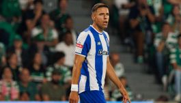 Na zdjęciu Jan Bednarek w barwach FC Porto, skupiony na boiskowych wydarzeniach podczas meczu ze Sportingiem CP. Ubrany w niebiesko-białą koszulkę z logo klubu i sponsorem Betano, symbolizuje nowy rozdział w swojej karierze. Tło wypełniają kibice rywali, co podkreśla atmosferę intensywnego spotkania (fot. Getty Images)