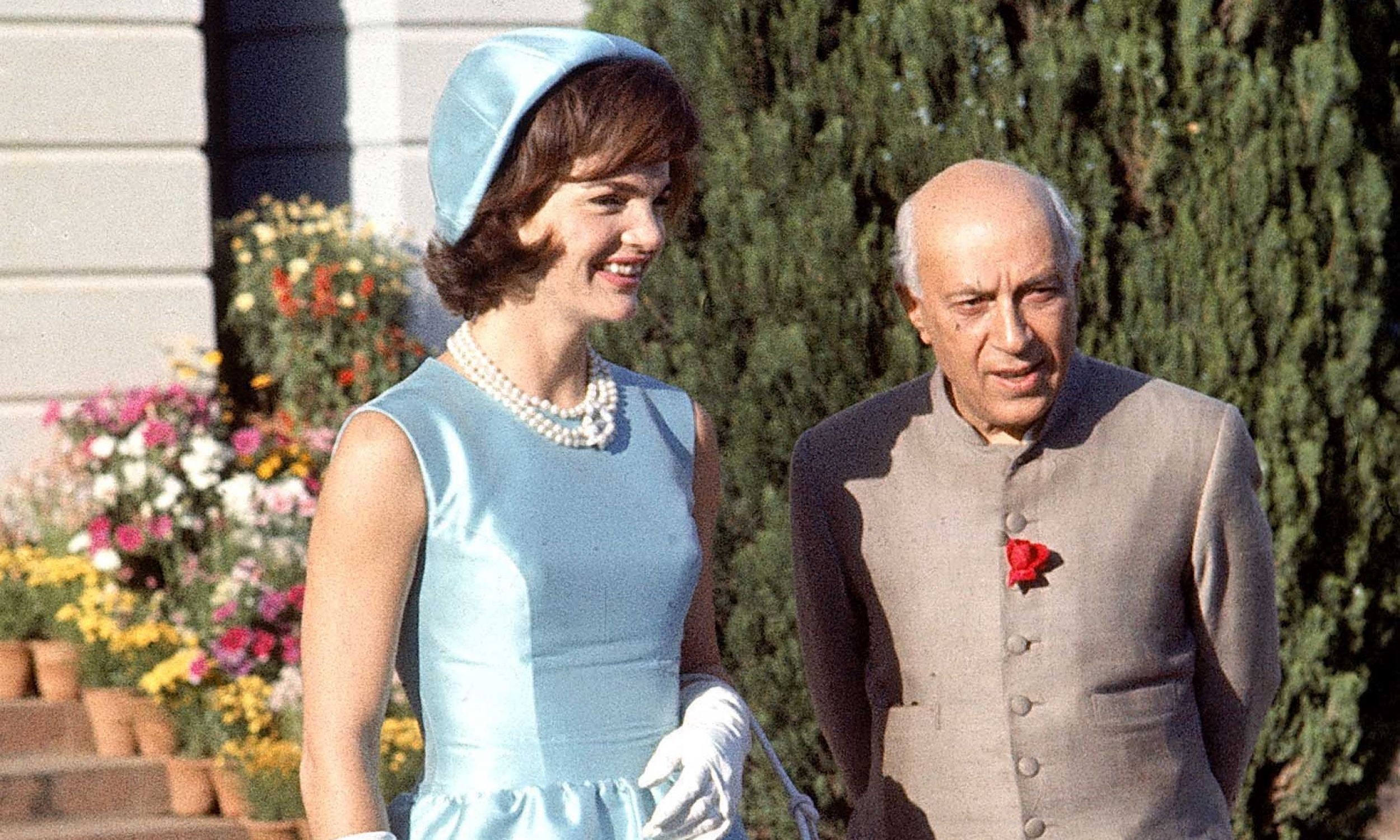 Zapoczątkowała modę na sukienki o szerokich ramiączkach i z wycięciem w łódkę. Na zdjęciu pierwsza dama Jackie Kennedy w niebieskiej sukience i kapeluszu spaceruje z premierem Indii Jawarhalalem Nehru w ogrodzie swojej rezydencji, w 1962 r. Fot. Art Rickerby / The LIFE Picture Collection via Getty Images