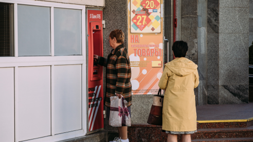 Людзі стаяць у чарзе да банкамату