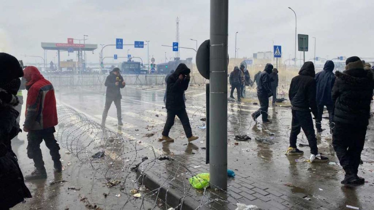 Imigranci szturmujący przejście graniczne w Kuźnicy (fot. Stringer/Anadolu Agency via Getty Images)