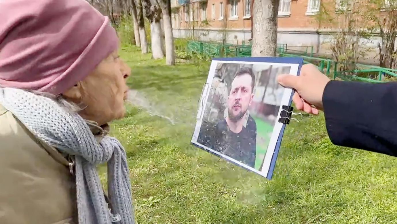 Ruska babuszka pluje na fotografię prezydenta Zełenskiego (fot. TT)