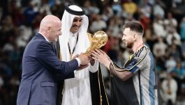 Leo Messi odbiera puchar za zwycięstwo w mistrzostwach świata w Katarze (fot. Getty Images)