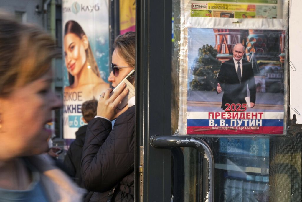 Людзі праходзяць міма календара на 2025 год з выявай Уладзіміра Пуціна, выстаўленага на продаж у газетным кіёску ў Санкт-Пецярбургу, Расея. 24 верасня 2024 года. Фота: Dmitri Lovetsky / AP Photo / East News